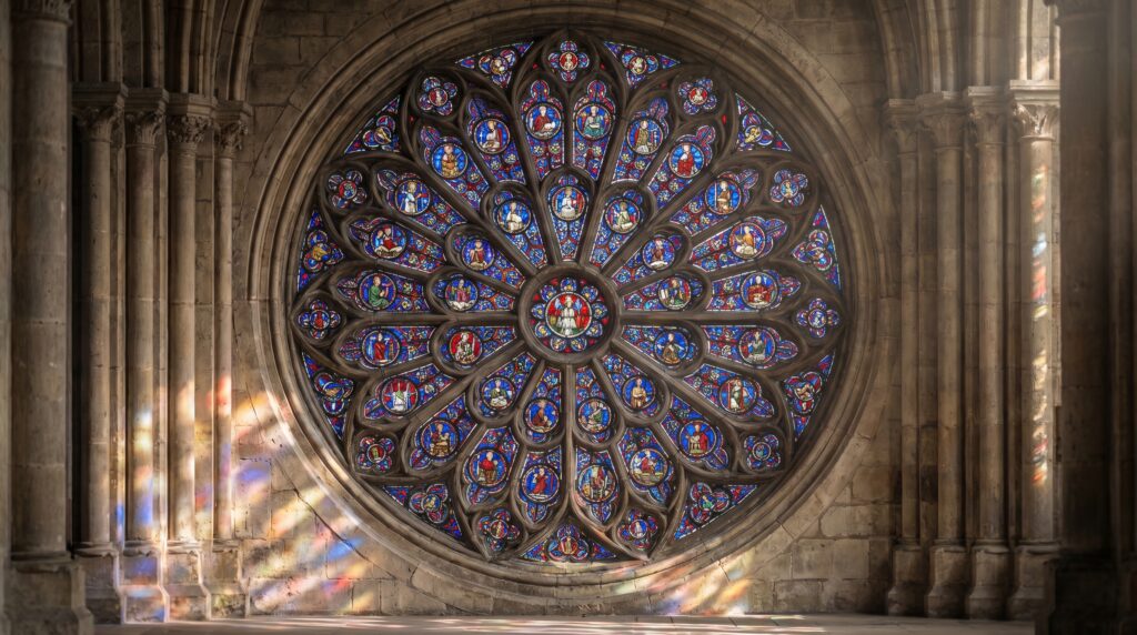 Detailed view of the historic rose window at Notre Dame Cathedral showcasing symmetrical patterns and sacred imagery