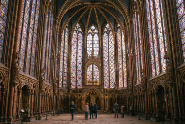 Upward view of Sainte Chapelle ceiling with Gothic arches and vibrant glass windows