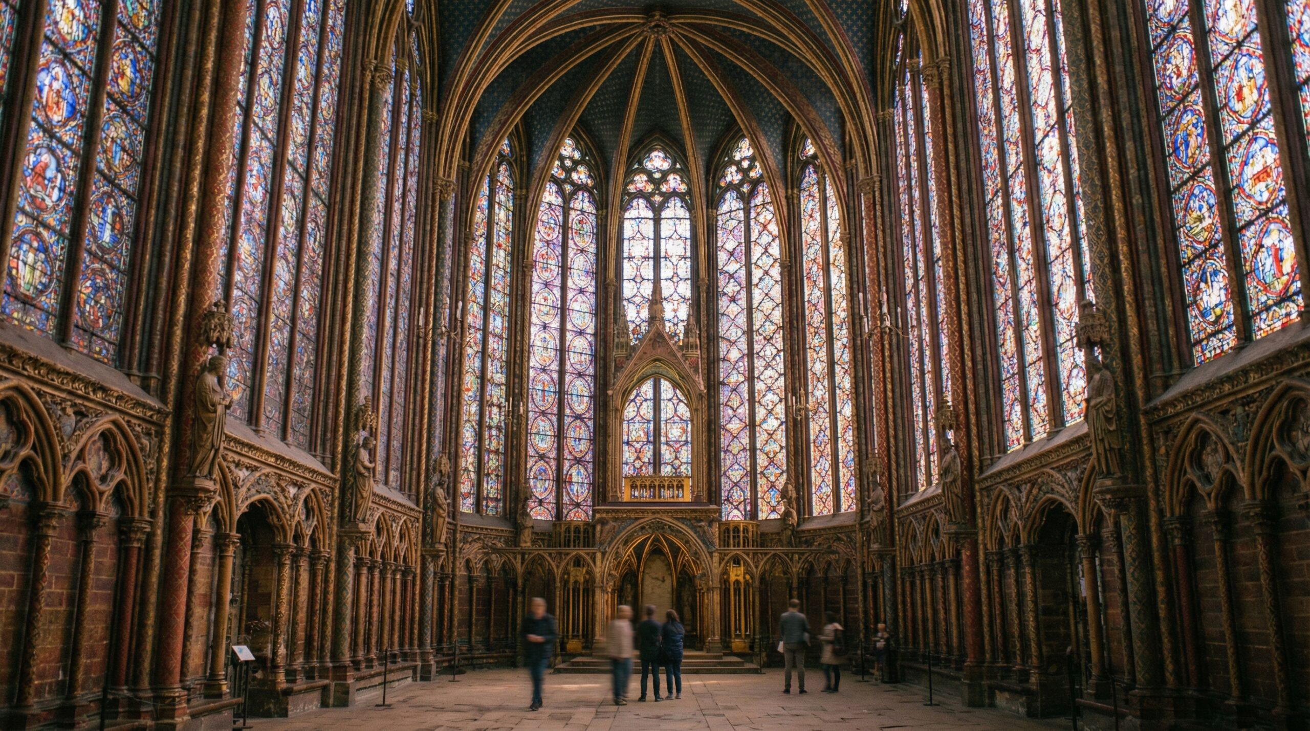 Upward view of Sainte Chapelle ceiling with Gothic arches and vibrant glass windows