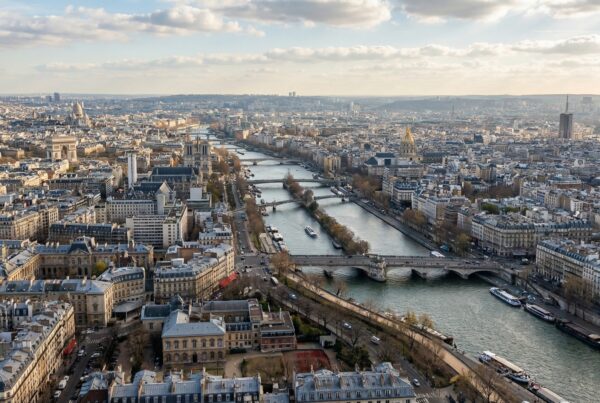 View from the Eiffel Tower summit overlooking the Seine River and historic Paris buildings